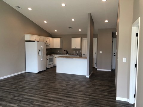 A kitchen with white appliances and cabinets is shown.