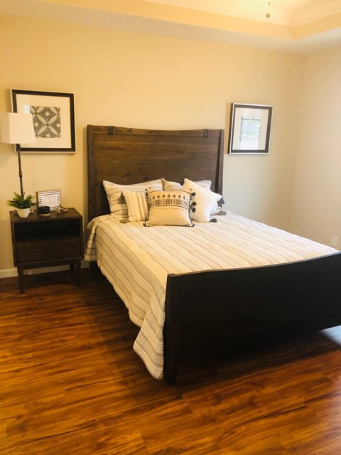 A bedroom with a large bed and a wooden headboard.