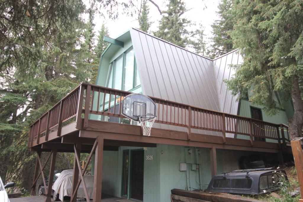 A house with a green exterior and a balcony.
