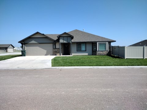 A house with a grey roof and a green lawn.