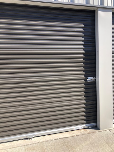 A closed grey shutter door with a white frame.