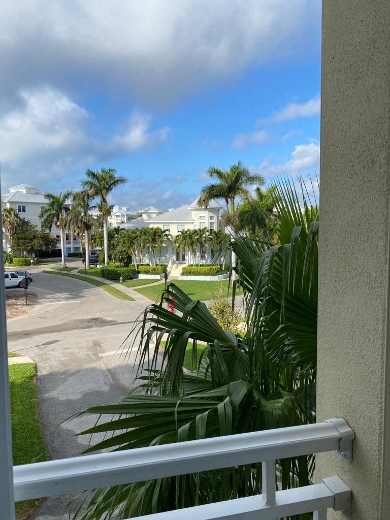 a view of the street from a balcony with palm trees