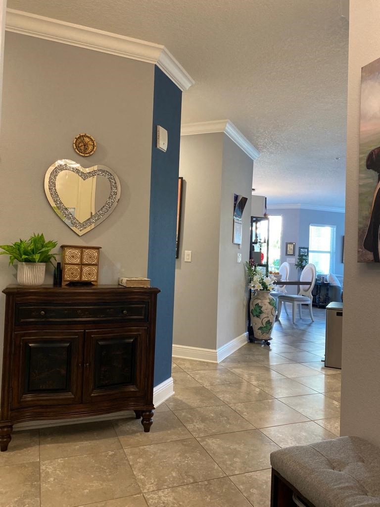 a hallway with a dresser and a heart shaped mirror on the wall