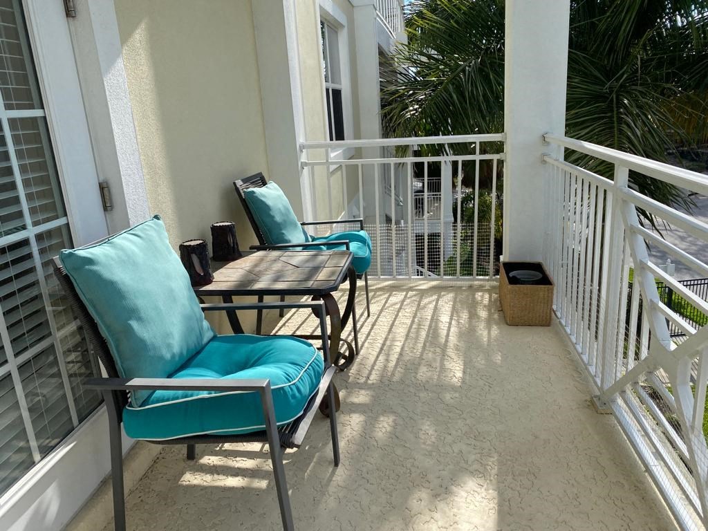 a patio with chairs and a table on a balcony