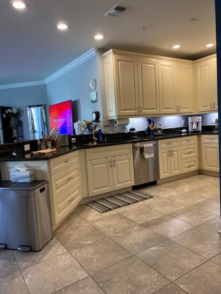 a kitchen with white cabinets and black counter tops