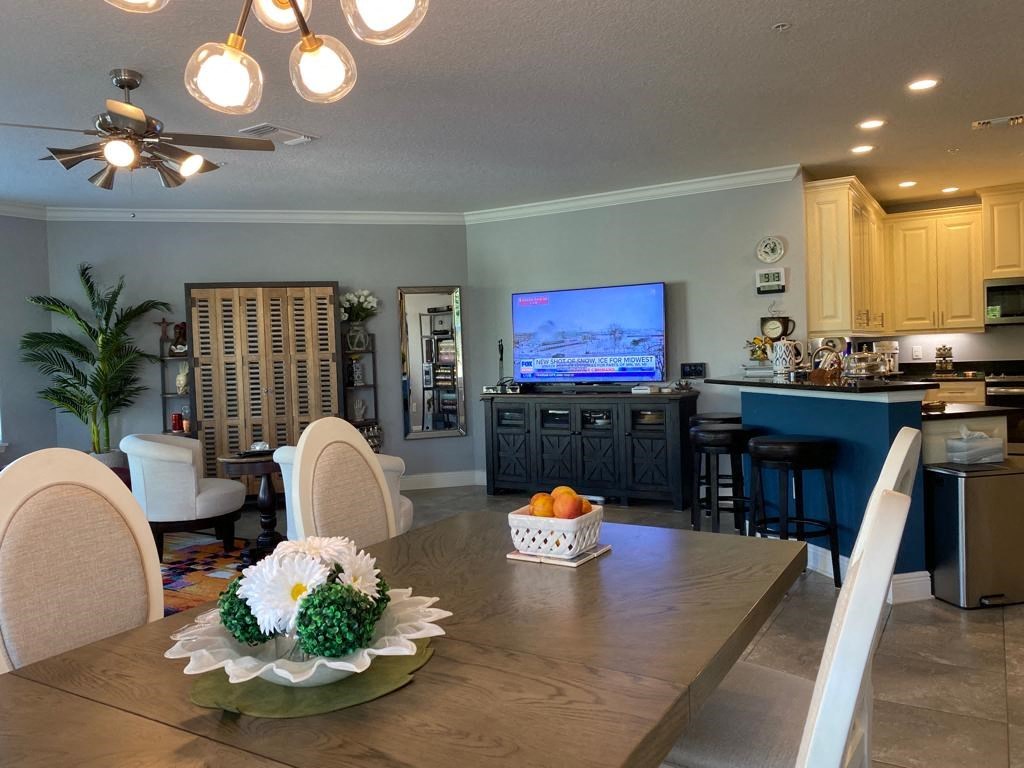 a dining room table with a view of a kitchen and a tv