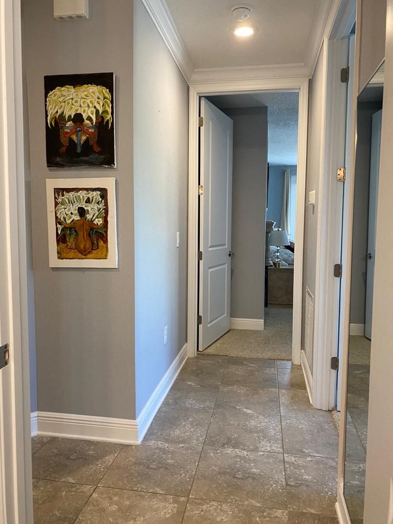 a hallway with tile floors and paintings on the wall