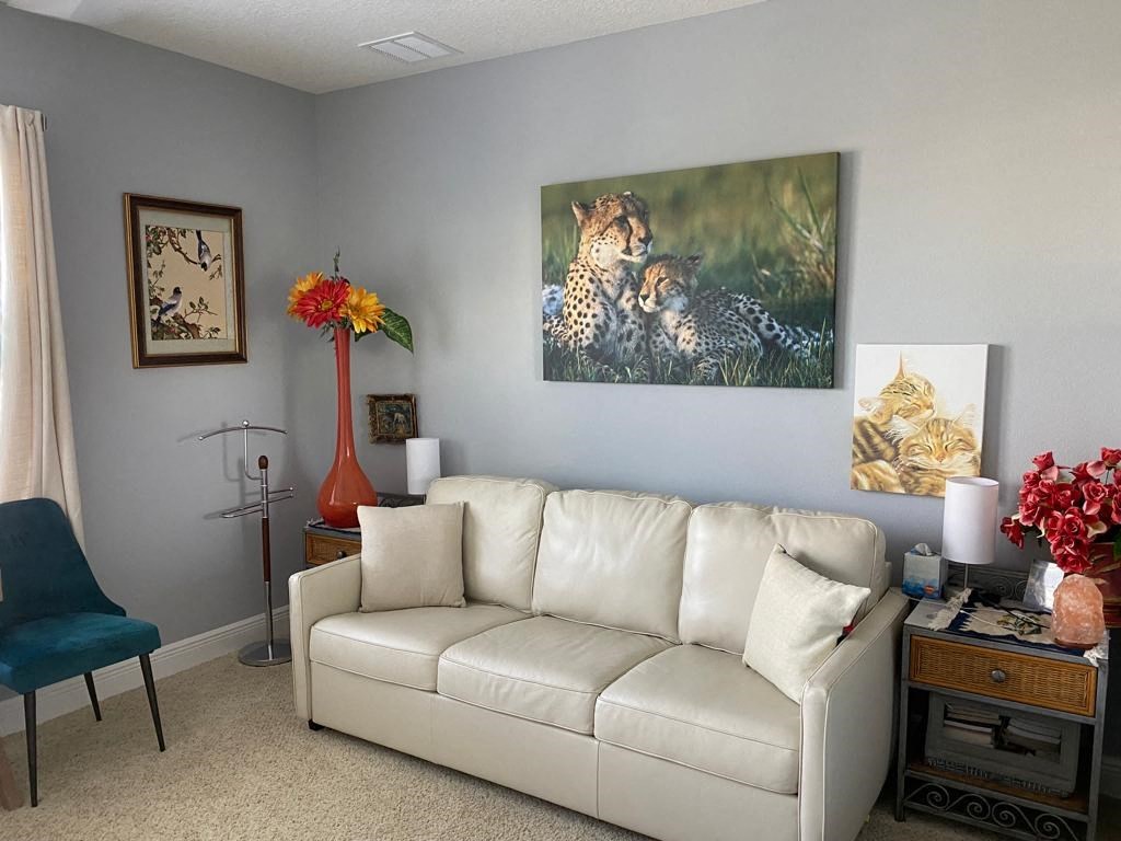 a living room with a couch and a painting of cheetahs