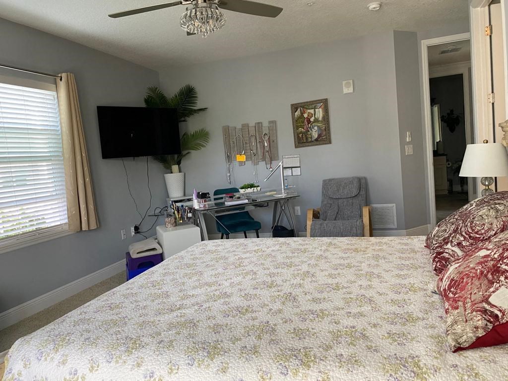 a bedroom with a bed and a desk and a tv