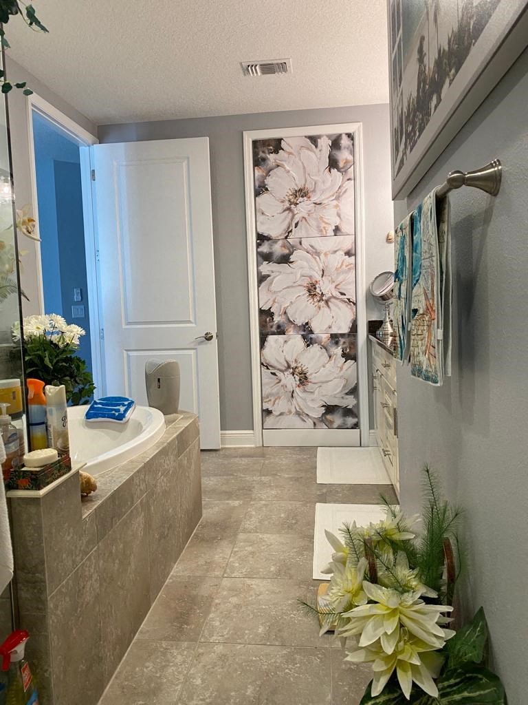 a bathroom with a tub and a shower and a painting on the wall