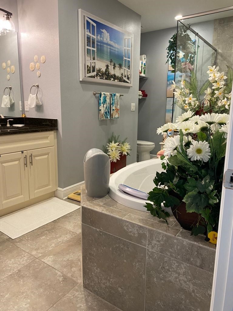 a bathroom with a tub and a vase of flowers