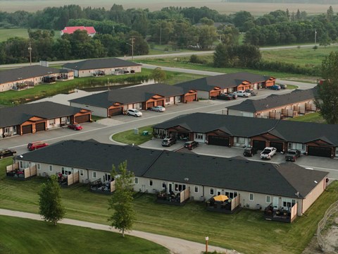 A large housing complex with multiple buildings and cars parked in the driveways.