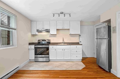 a kitchen with white cabinets and a stainless steel refrigerator