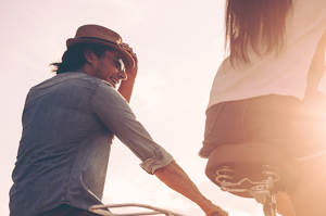 a man and a woman riding a bike down a road