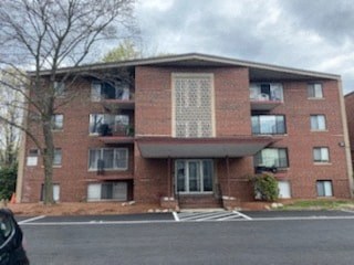 a red brick apartment building on the side of a street