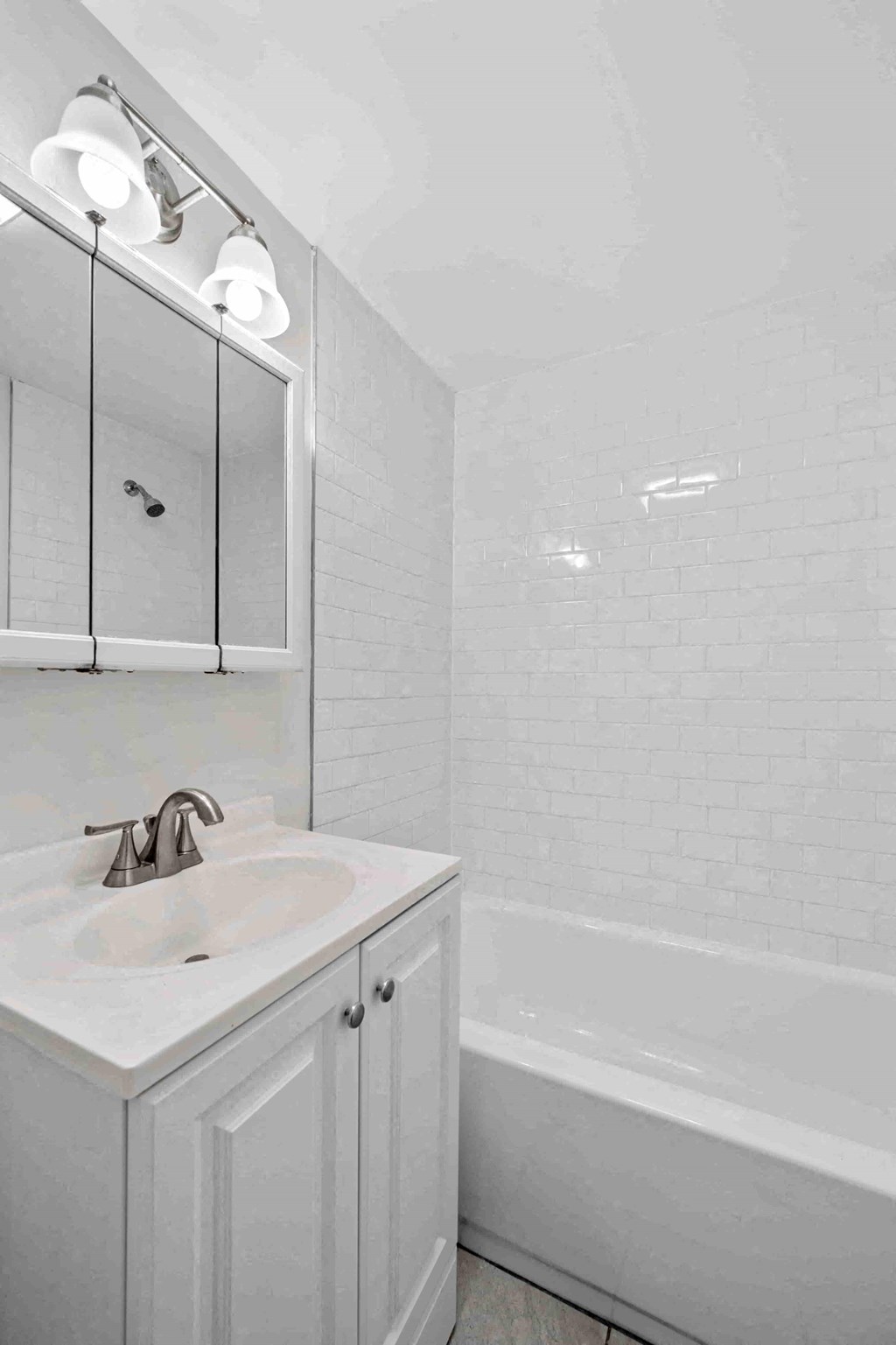 a white bathroom with a sink and a bath tub