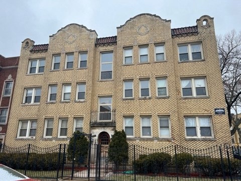 a large brick building with a fence in front of it