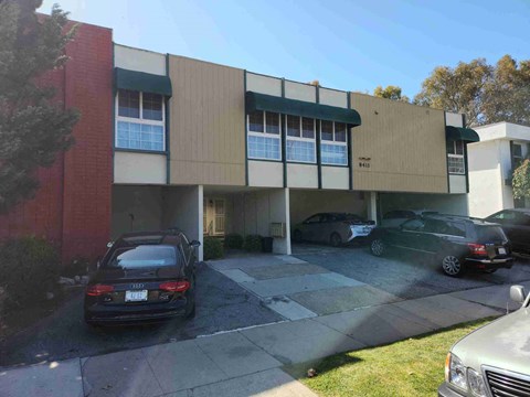 a view of the front of a building with cars parked outside
