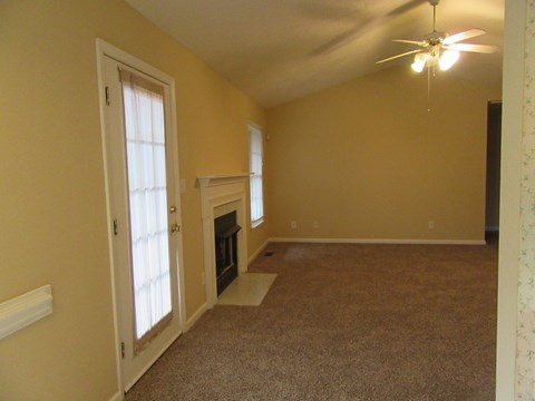 A room with a fireplace and a ceiling fan.
