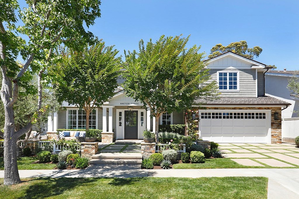 A house with a grey garage door and a white front door.