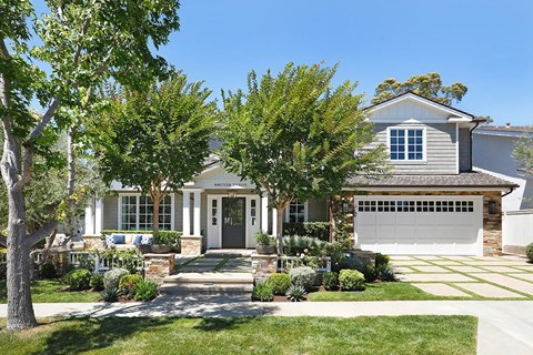 A house with a grey garage door and a white front door.