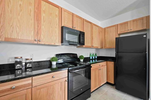 A kitchen with wooden cabinets and black appliances.