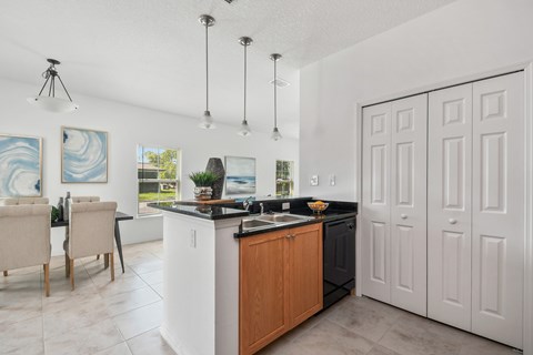 A kitchen with a black countertop and white cabinets.