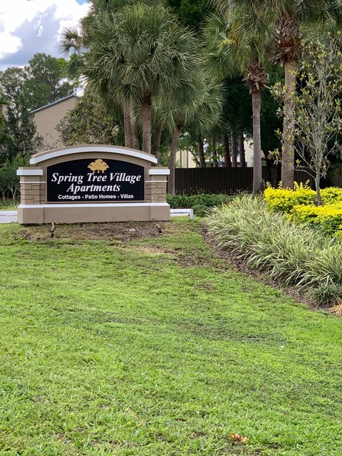 Spring Tree Village Apartments sign in front of a grassy area.