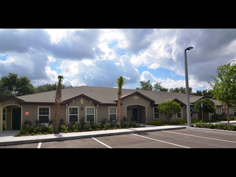A row of houses with a parking lot in front.