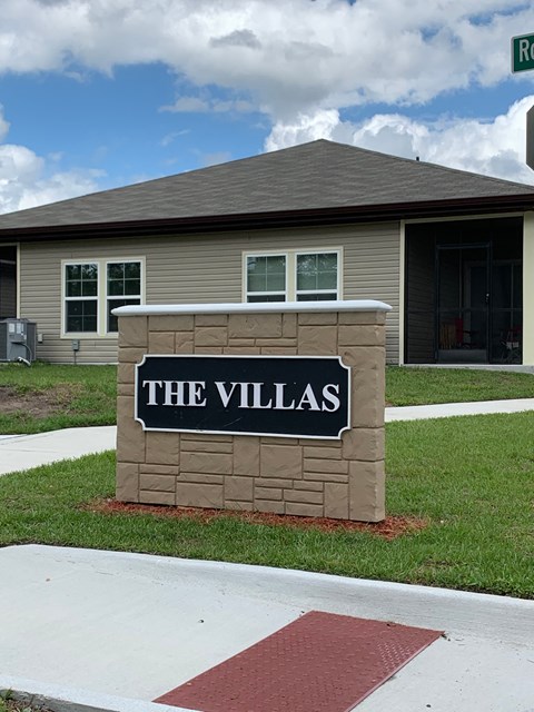 A sign that says "The Villas" in front of a building.