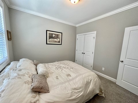 a bedroom with a bed and two closets and a window