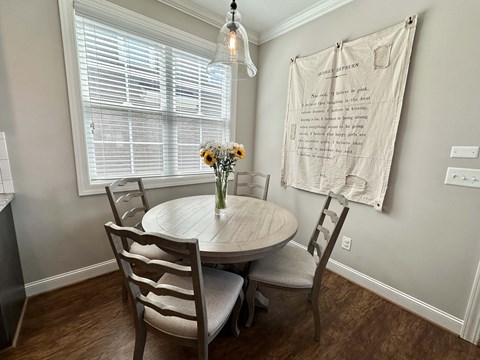 a dining room with a table and chairs and a window