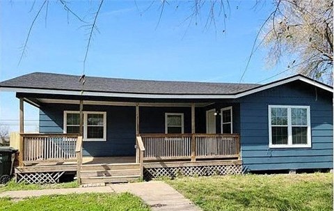 A blue house with a porch and a trash can.