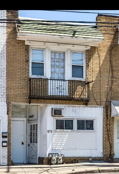 a brick house with a balcony and a white door