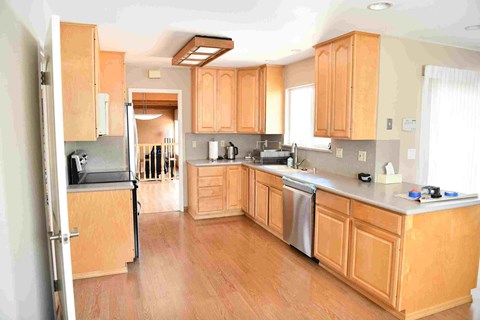 a large kitchen with wooden cabinets and stainless steel appliances