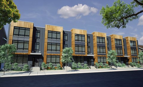 A row of modern buildings with wooden exteriors and glass windows.
