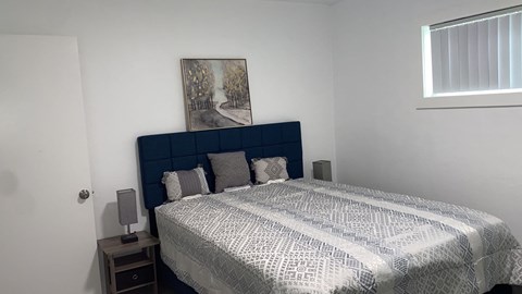 a bedroom with a bed and a painting on the wall