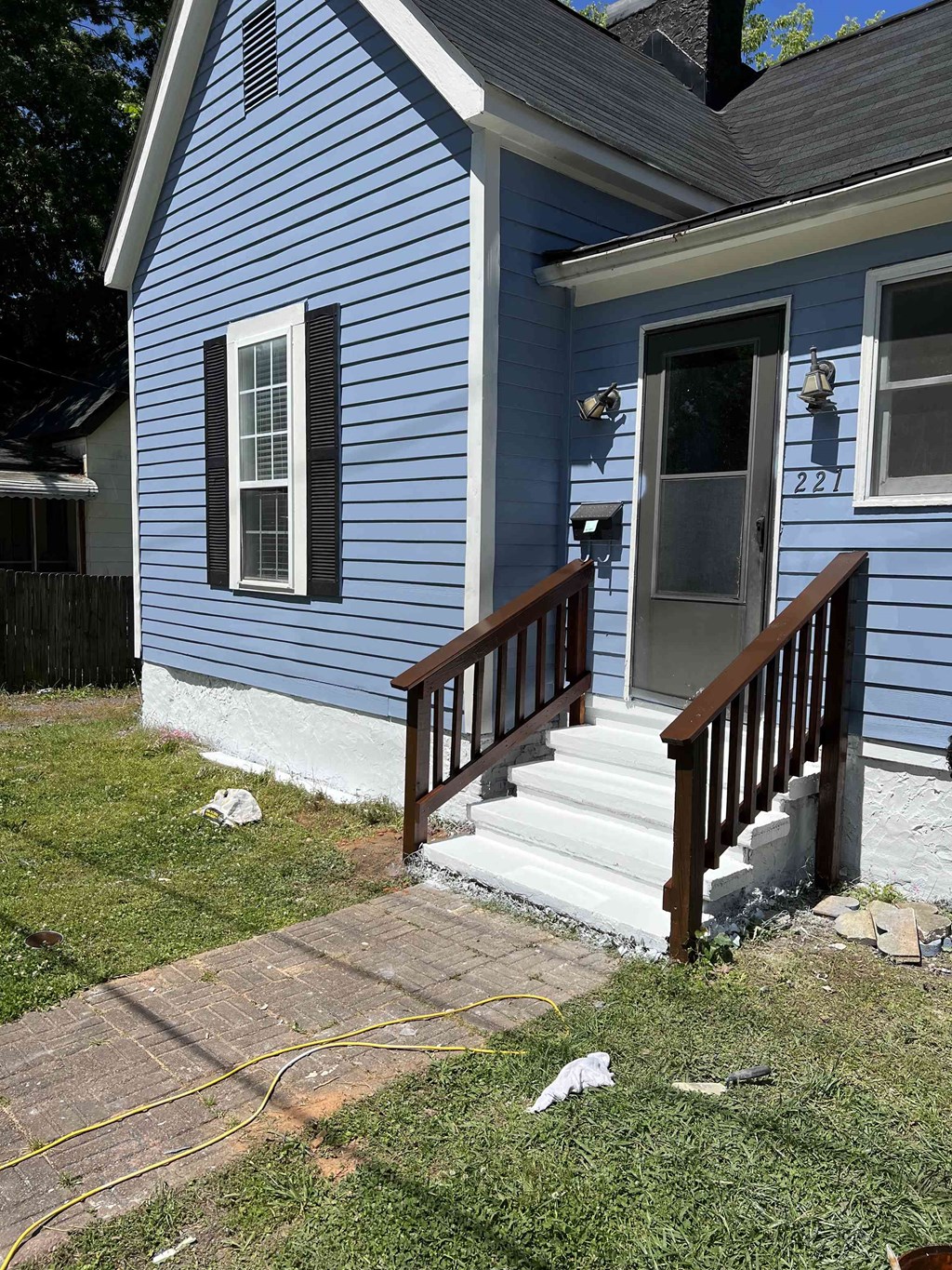 a blue house with a wooden porch and stairs