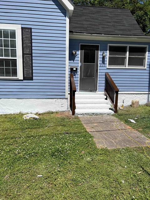 a blue house with a porch and a backdoor