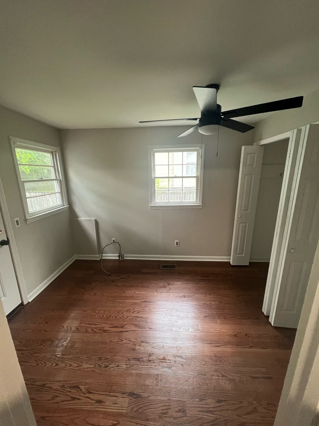 a living room with wood floors and a ceiling fan
