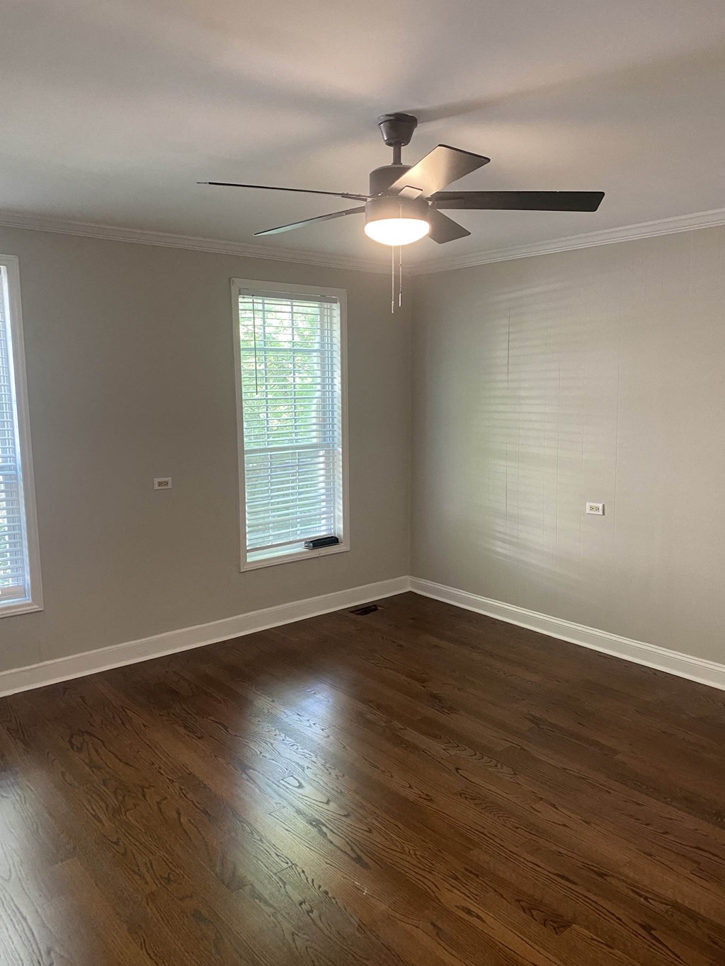 an empty living room with a ceiling fan and a window