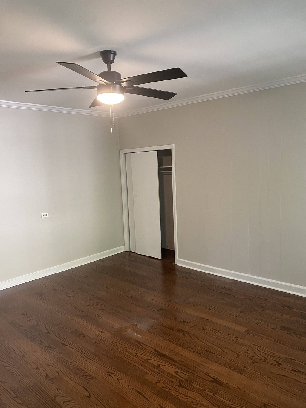 a living room with wood floors and a ceiling fan