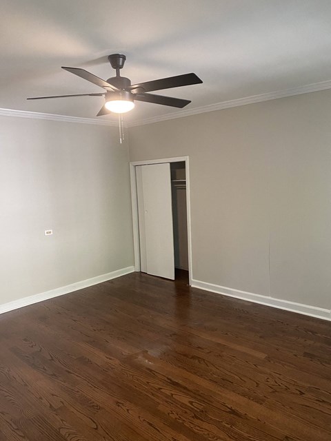 a living room with wood floors and a ceiling fan