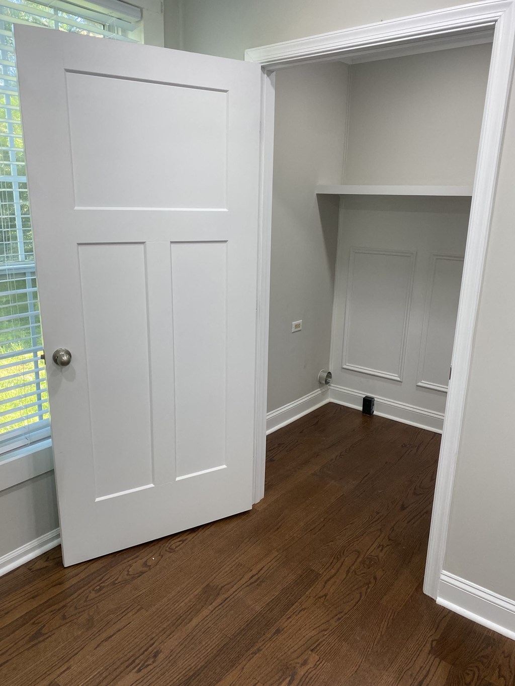 a room with a closet and a window and a wooden floor