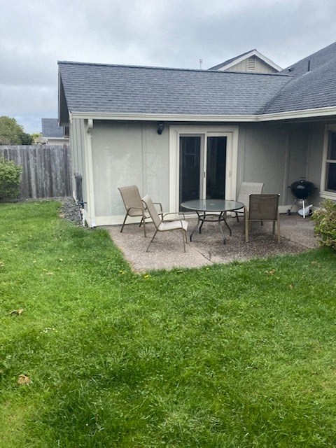 a patio with a table and chairs in front of a house