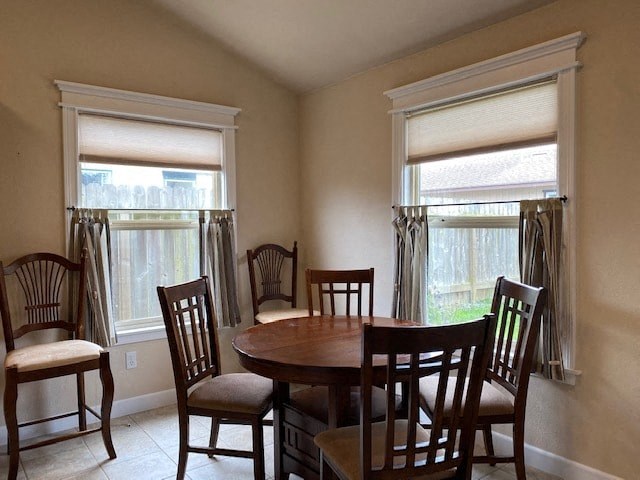 a dining room with a table and chairs and two windows