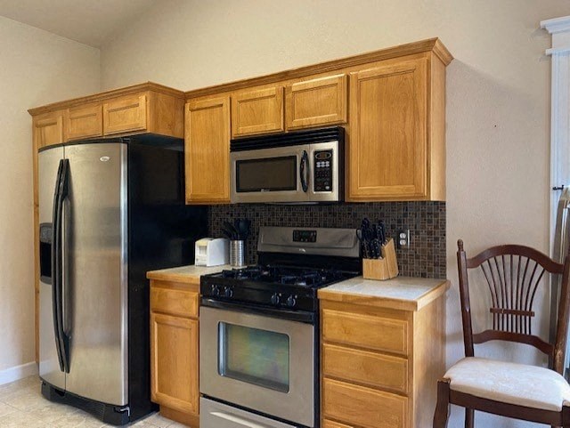a kitchen with stainless steel appliances and wooden cabinets