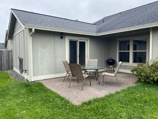 a patio with a table and chairs in front of a house