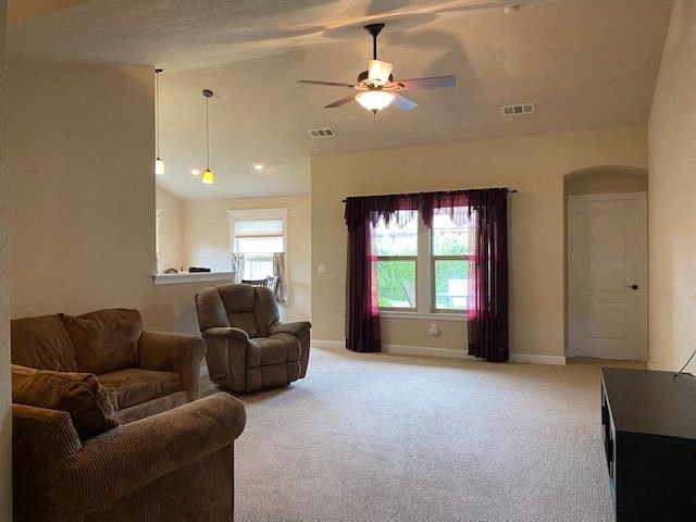 a living room with a couch and a chair and a ceiling fan