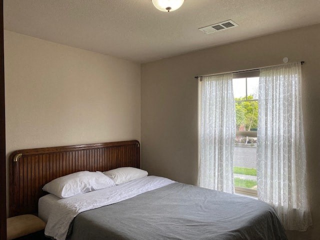 a bedroom with a bed and a large window